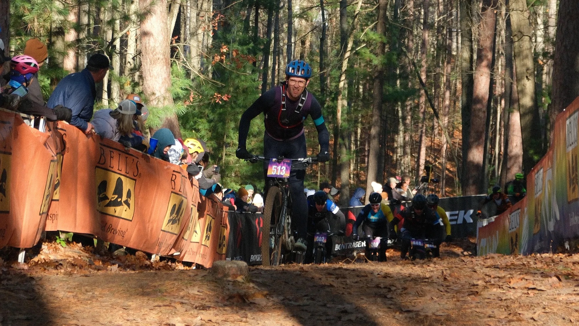 Cyclists climbing a forested section of the Iceman mountain bike race.